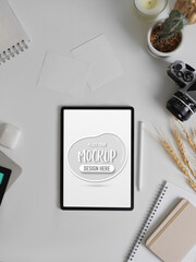 Mock up digital tablet on white table with camera, stationery, accessories and decorations