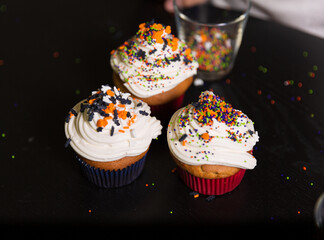 Boy decorating spooky Halloween cupcakes