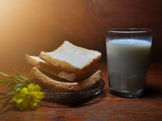 Dry rusk bread and a glass of milk isolated on wooden background. Healhty breakfast menu
