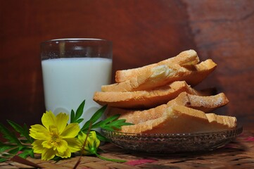 Dry rusk bread and a glass of milk isolated on wooden background. Healhty breakfast menu