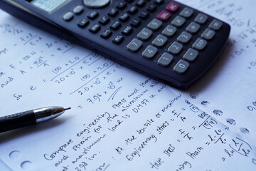 scientific math workout. sheet paper with solving equation math next to calculator