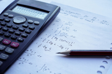 scientific math workout. sheet paper with solving equation math next to calculator