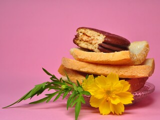 Fototapeta na wymiar Dry rusk bread and choco pie chocolate on pink background. Healhty breakfast menu