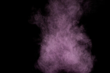 Purple powder explosion on black background. Colored powder cloud. Colorful dust explode. Paint Holi.