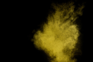 Yellow powder explosion on black background. Colored powder cloud. Colorful dust explode. Paint  Holi.