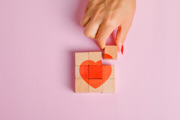 Relationship concept on pink background flat lay. finger pulling out wooden block.