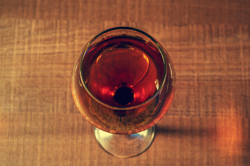 Glass of whiskey or rum on a wooden table, top view, for design