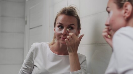 Woman Puts Patches On The Area Under The Eyes.