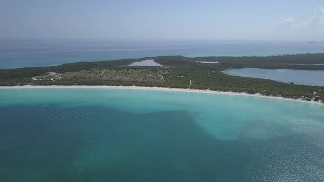 Drone descending on the white sandy beach and lagoon with crystal clear water 