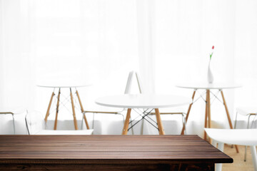 Empty wooden desk space and blurry background of cafe or Restaurant for product display montage