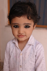 Very Cute Indian Kid Giving Pose To Camera With A Lovely Smile.