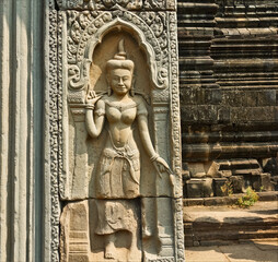 An ancient bas-relief in the unique Angkor temple. A female figure is carved in detail on the stone...