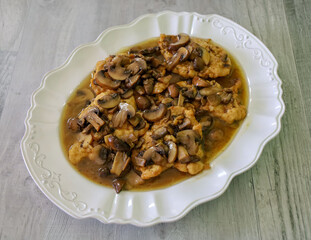 Top view of chicken marsala served on a white plater.