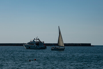 Fototapeta premium Two yachts in the sea bay in the rays of the evening sun.