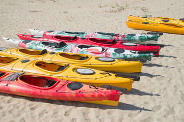 Many colorful sea tandem kayak on beach