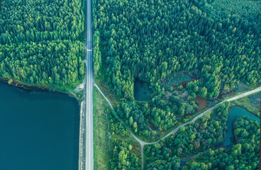 View from the drone. View from above on the dam. Road on the dam. Road. Green forest. Summer. Evening. Green.