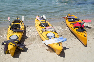 Three yellow sea tandem kayak on beach
