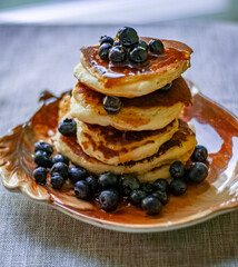 a stack of pancakes with blueberries and maple syrup