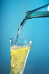 Fruit sparkling water is poured into a glass.