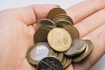 Fototapeta premium on the white man's hand are coins and kopecks. The concept of poverty in Belarus