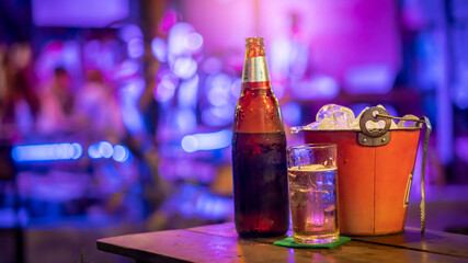 Beer glasses and bottles and ice buckets placed next to them on the table in the restaurant.