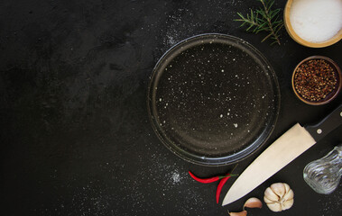 Empty black plate on a dark metal background. Top view with copy space.