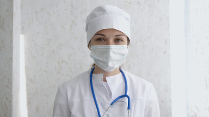 Female doctor or nurse in uniform and mask looking straight at camera. Hard work, medical, epidemic concept