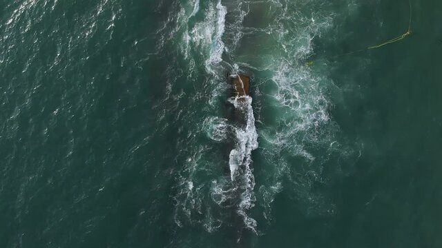 Vertical aerial footage of dismantling the dredger ship after excavating material from the sea bed.