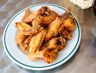 Delicious popular snack - pan-fried chicken wings with crispy crust..
