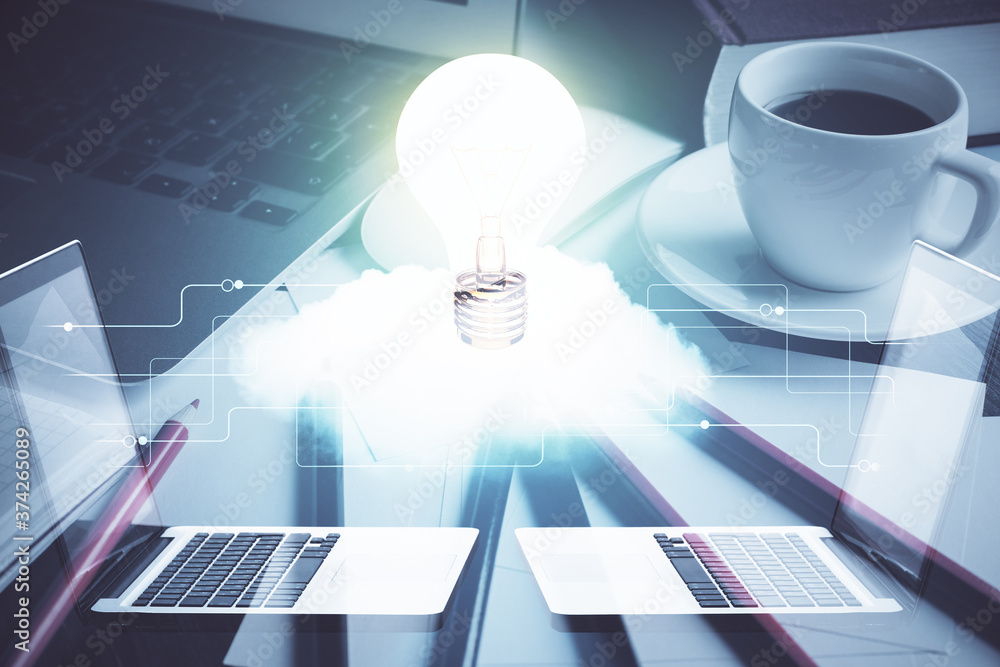 Poster computer on desktop in office with bulb icon hologram. double exposure. concept of idea.