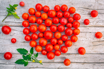 Fototapeta na wymiar Ripe cherry tomatoes arranged in a heart shape on a wooden background.