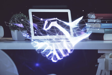 Desktop computer background in office and handshake hologram drawing. Double exposure. Pertnership concept.