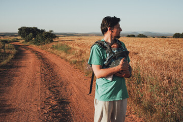 Single male parent carrying her baby with a backpack