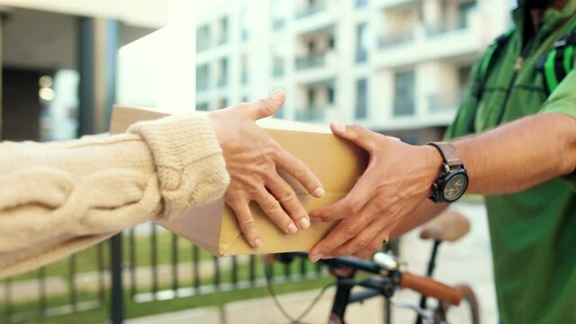 Young hands courier man with bicycle give box woman customer outdoor service home package send holding purchase postal shipment express parcel slow motion