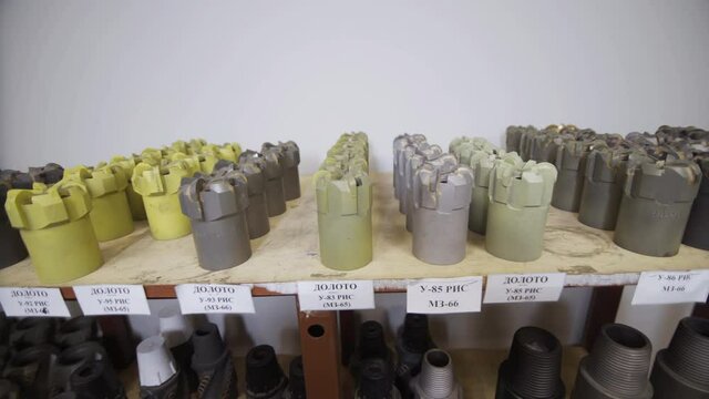 Drill Bits on shelving in stock. Oil drilling equipment for drilling rig operation on oil platform in oil and gas industry. Brand new PDC Polycrystalline Diamond Compact drilling bit