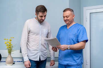 Obraz premium Male doctor and patient discussing methods of health issues treatment. Health care concept. Consultation at clinic.