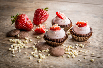 strawberry and chocolate pastries on woody background