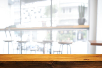 Empty wooden desk space and blurry background of cafe or Restaurant for product display montage