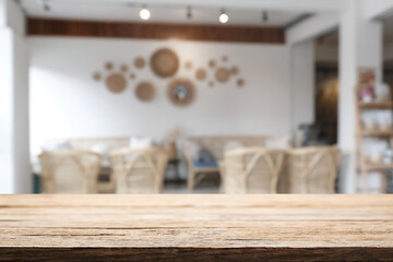 Empty wooden desk space and blurry background of cafe or Restaurant for product display montage