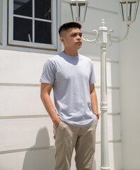 Young handsome man wearing heather grey t shirt short sleeve was posing at outdoor