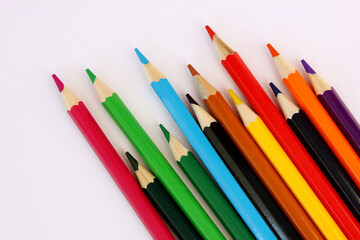 Colored pencils on white background. Many different colored pencils. Color pencil. Pencils are sharp. The pencils placed diagonally in lower right corner. Close-up. Copy space. Background. Flat lay