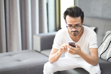 Happy young man using smartphone with application during stay at home, Chat, shopping online, working, connecting, mobile banking concept