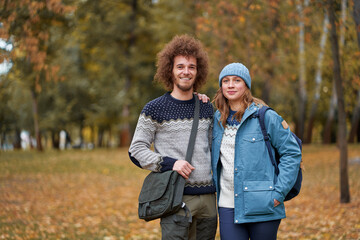 Naklejka na ściany i meble Holidays with friend. Young couple walking together in the park.