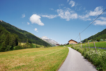 Fototapeta na wymiar Alpine mountains landscape. Village on green valley land.