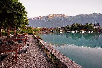 Fototapeta na wymiar Wooden cafe tables on the bay of Brienz lake, Switzerland.