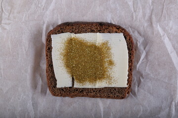 a sandwich with butter, spangles, onions and kiwi is on the table