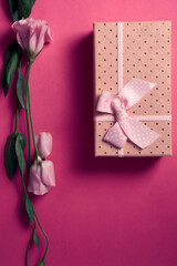 gift box and bouquet of flowers on pink background bow holidays top view