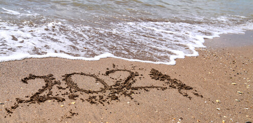 drawn numbers 2021 on the sea sand