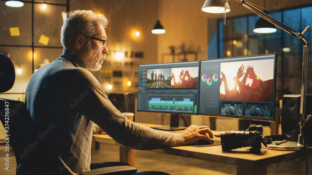 Poster evening in creative office: professional middle aged videographer works on desktop computer, doing f