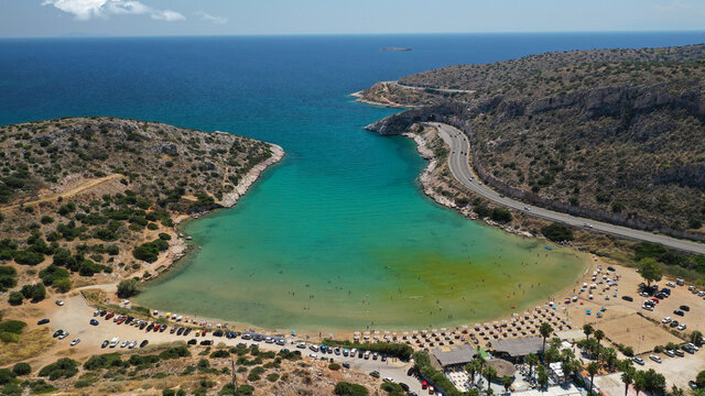 Aerial drone photo of small protected by winds cove and sandy beach of Lomvarda in Athens riviera next to Hole of Karamanlis tunnel, Vouliagmeni, Attica, Greece